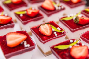 Zarif çilek bardakları krema, bisküvi ve ahududu soslu.