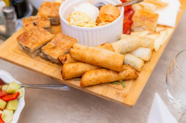 Kırsal Ahşap Servis Kurulunda çeşitli börekler, hamur işleri, soslar ve salata sergileniyor.