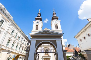 Romanya 'nın Timisoara kentindeki Sırp Ortodoks Katedrali' nin dış görünüşü, güzel mimarisini açık mavi bir gökyüzüne karşı sergiliyor. Din ve seyahat temaları için ideal.