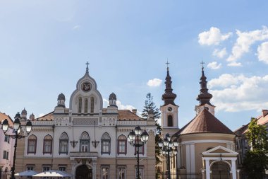 Açık mavi gökyüzü altında, Avrupa şehir manzarası altında, bir katedralin yanında kendine özgü kubbe ve haçların yer aldığı tarihi kent mimarisinin görüntüsü. Timisoara, Romanya