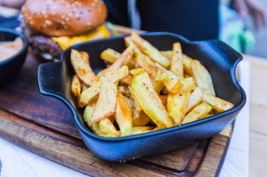 Siyah dökme demir restoranın kalitesinde konforlu gıdalarla sunulan kahverengi ev usulü patates kızartması..