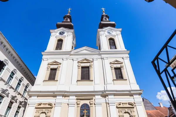 Romanya 'nın Timisoara kentindeki Sırp Ortodoks Katedrali' nin dış görünüşü, güzel mimarisini açık mavi bir gökyüzüne karşı sergiliyor. Din ve seyahat temaları için ideal.
