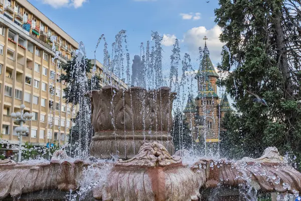 Romanya 'nın muhteşem Ortodoks Katedrali' ne doğru bir manzara sunan Timisoara 'nın hareketli Zafer Meydanı' nın (Piata Victoriei) ön planında ferahlatıcı çeşmeler akıyor.