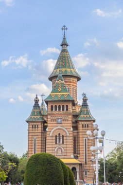 Timisoara Ortodoks Metropolitan Katedrali 'nin çarpıcı manzarası. Romanya 'da güzel kuleleri, ayrıntılı cephesi ve canlı yeşil bahçeleri olan ikonik dini simgeler.