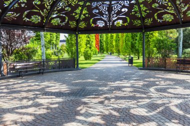 Manikürlü Park ve Taş Patika Yerleşimine Bakan Çiçek Kesikleriyle Süslü Metal Gazebo