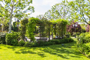 Dekoratif Aydınlatma ile döşenmiş Şehir Parkı 'ndaki Tırmanma Santralleri ve Bankları ile Modern Bahçe Pergola