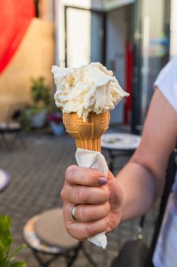 Güneşli bir günde el ele tutuşan leziz dondurma külahı.