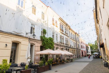 Geleneksel Avrupa Mimarisi Cafe Terasları ve Dekoratif İp Işıkları Romantik Atmosfer Oluşturan Tarihi Timisoara Romanya Eski Şehir Caddesine Zarar Vermek