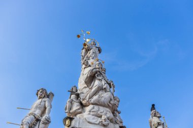 Romanya 'nın Timisoara kentindeki tarihi Özgürlük Meydanı' nda belirgin bir şekilde duran, birden fazla figür ve heykelle süslenmiş uzun ve süslü taş bir heykelin ayrıntılı manzarası.