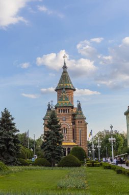 Timisoara Ortodoks Metropolitan Katedrali 'nin canlı ve görkemli manzarası kendine özgü mimari tarzını ve renkli çatısını dinamik bir gökyüzüne karşı sergiliyor..