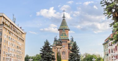 Timisoara Ortodoks Metropolitan Katedrali 'nin canlı ve görkemli manzarası kendine özgü mimari tarzını ve renkli çatısını dinamik bir gökyüzüne karşı sergiliyor..