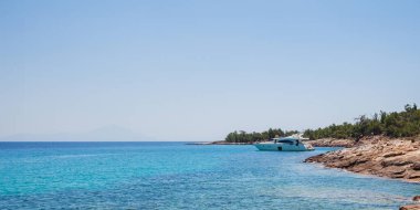 Kristal berrak Turkuaz Suları ve Rocky Sahil Hattı ile Tenha Yunan Adası Koyu 'na demirli Lüks Yat