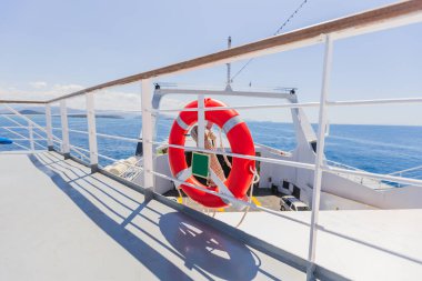Kırmızı Hayat Halkası Güvenlik Ekipmanı Beyaz Feribot Güvertesinde Okyanus manzaralı ve Mavi Gökyüzü Deniz Taşımacılığı