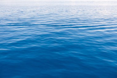 Yumuşak Doğal Işık Altında Yumuşak Dalgalanmalar ile Sakin Mavi Deniz 'in Sakin Yüzeyi Doğa, Sağlık, Meditasyon İçin Minimalist Okyanus Arkaplanı veya Kopya Uzay ve Huzur Atmosferi ile Seyahat Kavramları