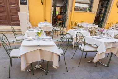 Korfu 'da geleneksel bir Yunan restoranında boş bir açık hava koltuğu.