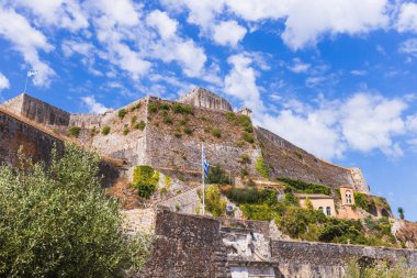 Venedikliler tarafından inşa edilen Yeni Kale 'nin devasa taş duvarları eski Korfu limanının üzerinde, parlak, açık mavi bir gökyüzünün altında yükseliyor..