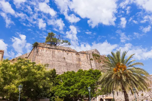 Venedikliler tarafından inşa edilen Yeni Kale 'nin devasa taş duvarları eski Korfu limanının üzerinde, parlak, açık mavi bir gökyüzünün altında yükseliyor..
