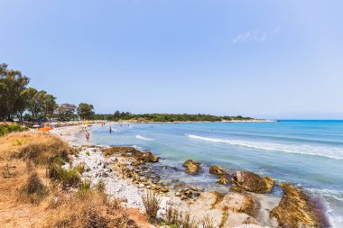 Akdeniz 'in işlek sahil cenneti. Aileler kristal berrak turkuaz suların, beyaz kumlu sahillerin ve dramatik kayalık kıyı manzarasının keyfini çıkarıyorlar..