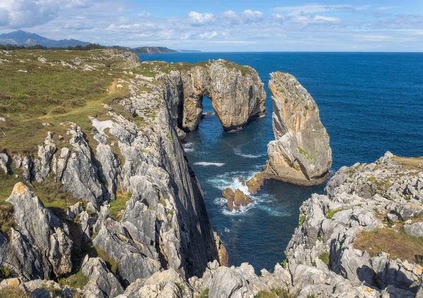 西班牙阿斯图里亚斯一个宁静的地狱悬崖场景揭示了一个壮观的岩石海岸 从海上延伸到一个令人印象深刻的岩石结构周围是陆地和天空 — 图库照片