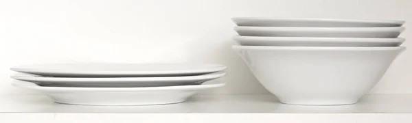 stock image Stack of white plates on shelf