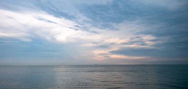 Gökyüzü mavi ve bulutlu. Su çok sakin. Görüntüde hiç insan yok.