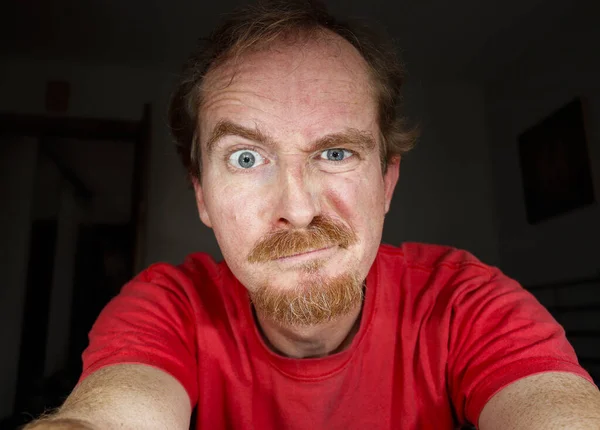 Rudowłosy Mężczyzna Patrzy Ekran Swojego Komputera Lub Tabletu Czytając Coś — Zdjęcie stockowe