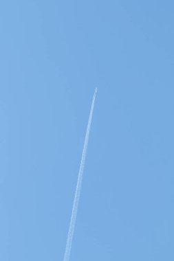 high in the blue sky the trail of an airplane
