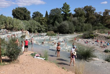 Saturnia, İtalya - 13 Eylül 2022 İnsanlar Satürn 'ün kaplıcalarında banyo yapıyorlar Therme, Saturnia, Toskana, İtalya 