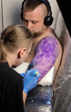 Krakow, Poland -  June 11, 2022: Unidentified  participant at 15th Tattoofest Convention in Cracow. One of the most prestigious tattoo festivals. Tattoo artist at work. 