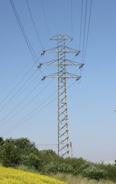 high voltage power pole and lines against the blue sky