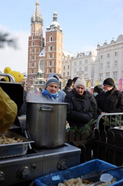 Krakow, Polonya - 18 Aralık 2022: Krakow 'daki ana meydandaki fakir ve evsizler için Noel arifesi. Kosciuszko grubu Krakow 'daki açık havada en büyük arifeyi hazırlıyor