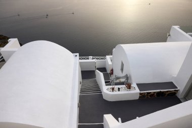 Imerovigli, Santorini, Yunanistan - 1 Temmuz 2021: Yunanistan 'ın Santorini adasındaki Imerovigli adasında terasları ve havuzları olan beyaz boyalı evler ve güzel bir manzara 