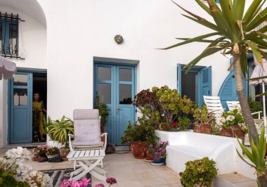 Imerovigli, Santorini, Greece - June 29, 2021: Flowers in ceramic pots in front of a whitewashed house in Imerovigli on Santorini island, Cyclades, Greece 