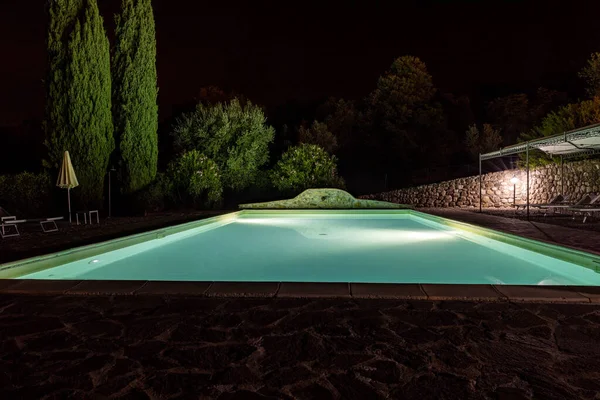 位于格罗斯托省的蒙泰马西山坡上的一个灯火通明的游泳池 四周环绕着柏树和百合花 意大利 — 图库照片
