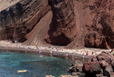 Santorini, Yunanistan - 01 Temmuz 2021: Santorini adasının güney kıyısındaki ünlü Kızıl Kumsal, Kiklad, Ege Denizi.