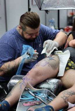 Krakow, Poland -  June 11, 2022: Unidentified  participant at 15th Tattoofest Convention in Cracow. One of the most prestigious tattoo festivals. Tattoo artist at work. 