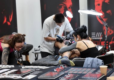 Krakow, Poland -  June 11, 2022: Unidentified  participant at 15th Tattoofest Convention in Cracow. One of the most prestigious tattoo festivals. Tattoo artist at work. 