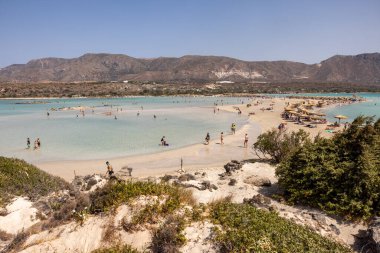 Elafonisi, Girit, Yunanistan - 19 Eylül 2021: Girit, Akdeniz 'deki Elafonisi' nin ünlü pembe mercan plajında dinlenen insanlar 