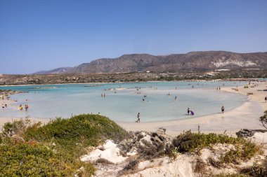 Elafonisi, Girit, Yunanistan - 19 Eylül 2021: Girit, Akdeniz 'deki Elafonisi' nin ünlü pembe mercan plajında dinlenen insanlar 