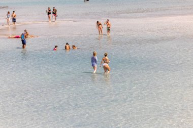 Elafonisi, Girit, Yunanistan - 19 Eylül 2021: Girit, Akdeniz 'deki Elafonisi' nin ünlü pembe mercan plajında dinlenen insanlar 