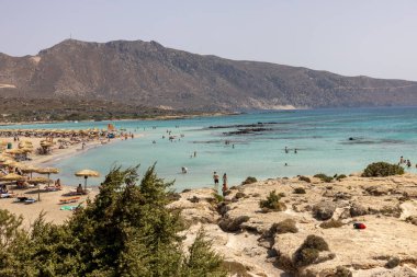 Elafonisi, Girit, Yunanistan - 19 Eylül 2021: Girit, Akdeniz 'deki Elafonisi' nin ünlü pembe mercan plajında dinlenen insanlar 