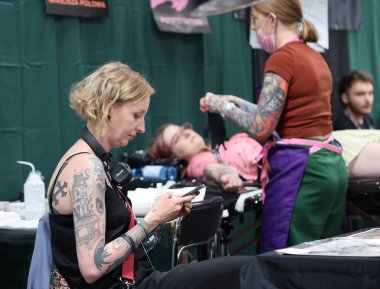 Krakow, Poland -  June 11, 2022: Unidentified  participant at 15th Tattoofest Convention in Cracow. One of the most prestigious tattoo festivals. Tattoo artist at work. 