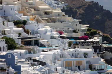 Oia, Santorini, Yunanistan - 3 Temmuz 2021: Yunanistan 'ın Santorini adasındaki Oia' da teras ve havuzlu ve güzel manzaralı bembeyaz evler 