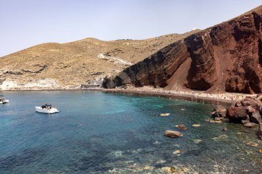 Santorini, Yunanistan - 01 Temmuz 2021: Santorini adasının güney kıyısındaki ünlü Kızıl Kumsal, Kiklad, Ege Denizi.