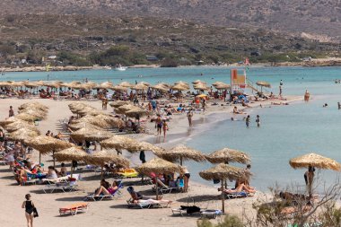 Elafonisi, Girit, Yunanistan - 19 Eylül 2021: Girit, Akdeniz 'deki Elafonisi' nin ünlü pembe mercan plajında dinlenen insanlar 