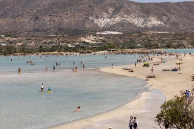 Elafonisi, Girit, Yunanistan - 19 Eylül 2021: Girit, Akdeniz 'deki Elafonisi' nin ünlü pembe mercan plajında dinlenen insanlar 