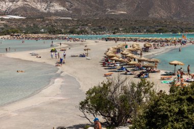 Elafonisi, Girit, Yunanistan - 19 Eylül 2021: Girit, Akdeniz 'deki Elafonisi' nin ünlü pembe mercan plajında dinlenen insanlar 