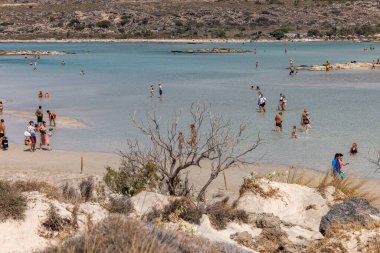 Elafonisi, Girit, Yunanistan - 19 Eylül 2021: Girit, Akdeniz 'deki Elafonisi' nin ünlü pembe mercan plajında dinlenen insanlar 