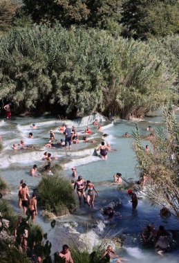 Saturnia, İtalya - 13 Eylül 2022 İnsanlar Satürn 'ün kaplıcalarında banyo yapıyorlar Therme, Saturnia, Toskana, İtalya 