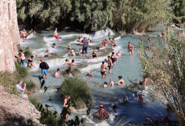 Saturnia, İtalya - 13 Eylül 2022 İnsanlar Satürn 'ün kaplıcalarında banyo yapıyorlar Therme, Saturnia, Toskana, İtalya 